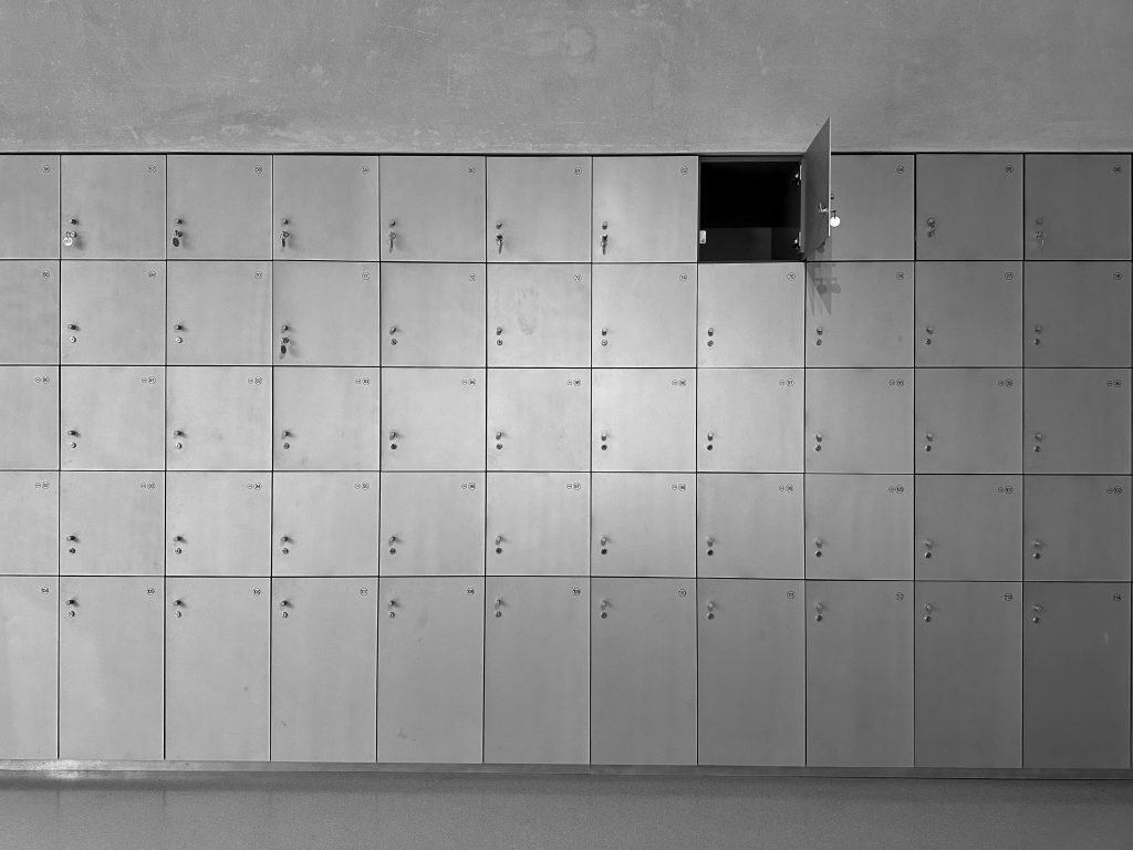 A sleek wall of lockers with one door open, showcasing minimalist design.